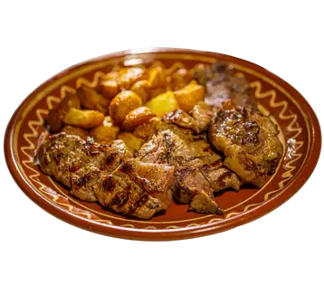 Grilovano meso sa krompirom na tanjiru.