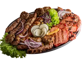 Pomešano meso i povrće na ovalnom tanjiru.