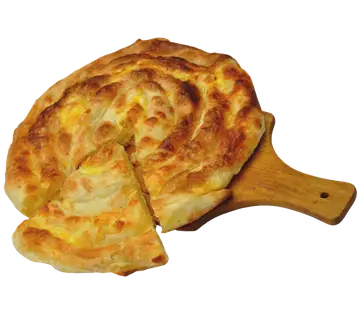 Okrugla pita na drvenoj dasci sa isečenim parčetom.